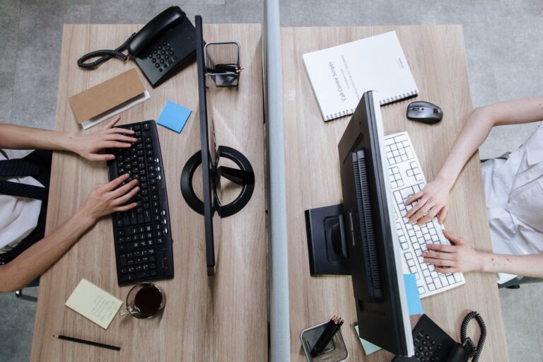 Person Using Computer on Brown Wooden Desk